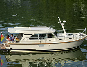 Linssen GS 30 Sedan Amy, Steuerbordansicht, 2 Personen am Tisch an der Hecksitzgruppe