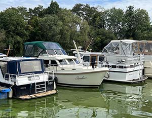 Linssen 30.9 Simba mit Heck am Anleger zwischen 2 Yachten. Blick auf Steuerbordseite und Bug